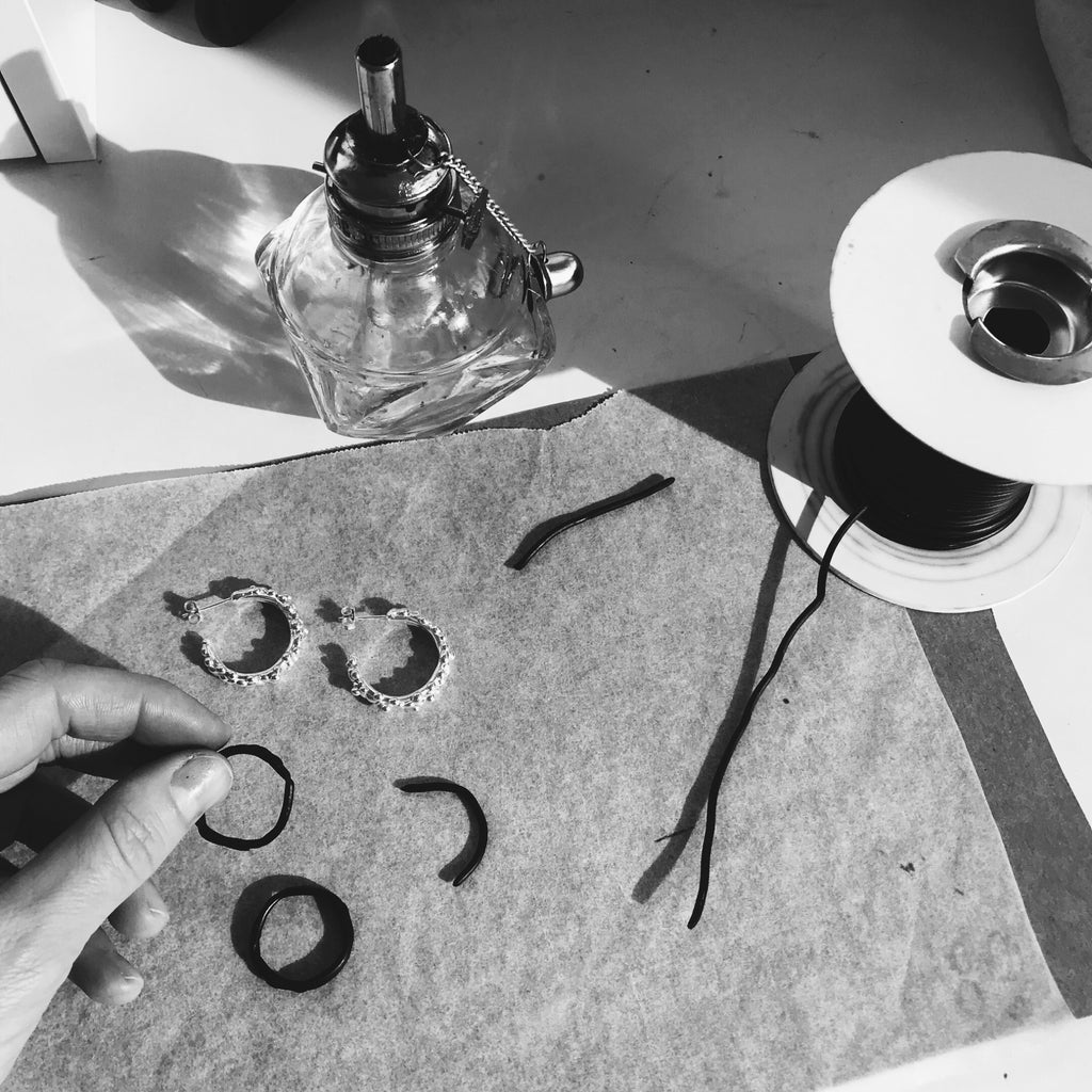 Hand forming a pair of earrings using wax wire, which will then be cast into sterling silver.
